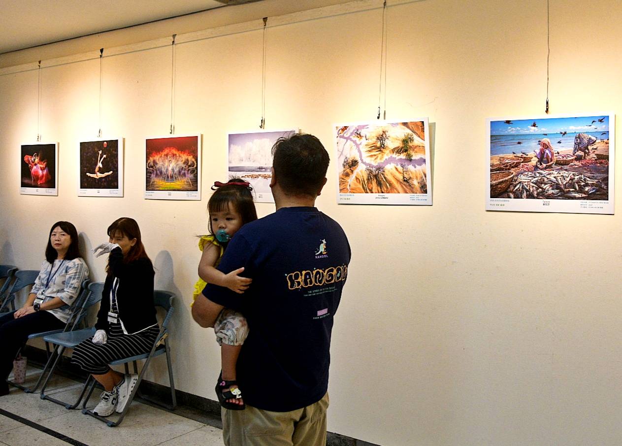 民眾攜家帶眷走進展場，欣賞攝影作品。