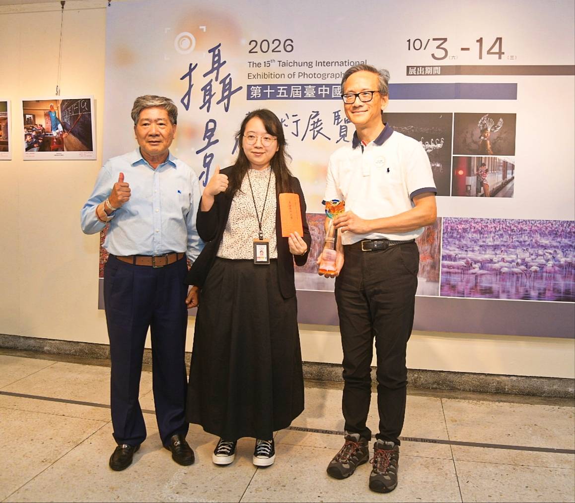 臺中市攝影學會何理事長頒獎並與得獎者合影。