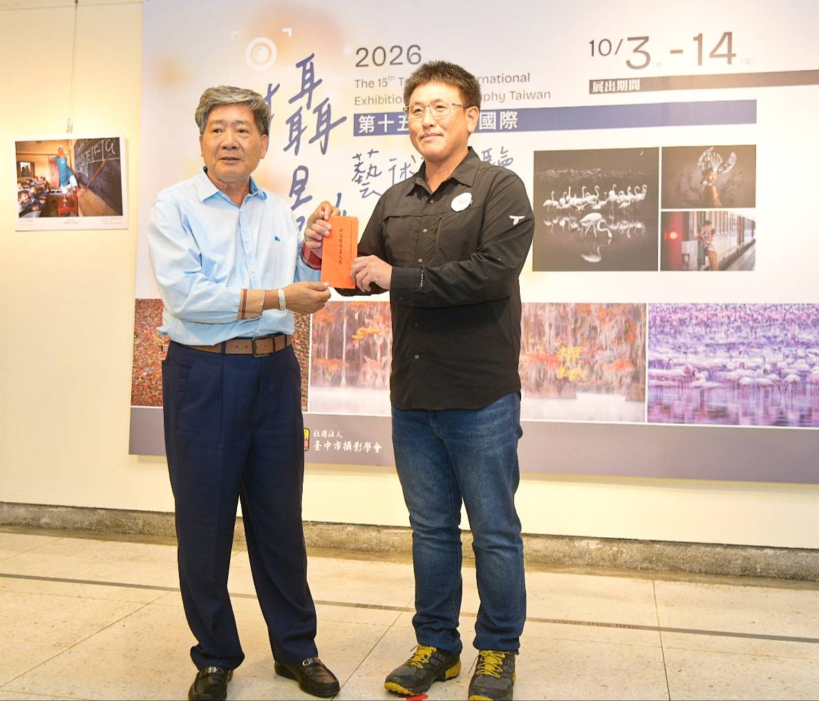 臺中市攝影學會何理事長於頒獎活動中與受獎者合影。
